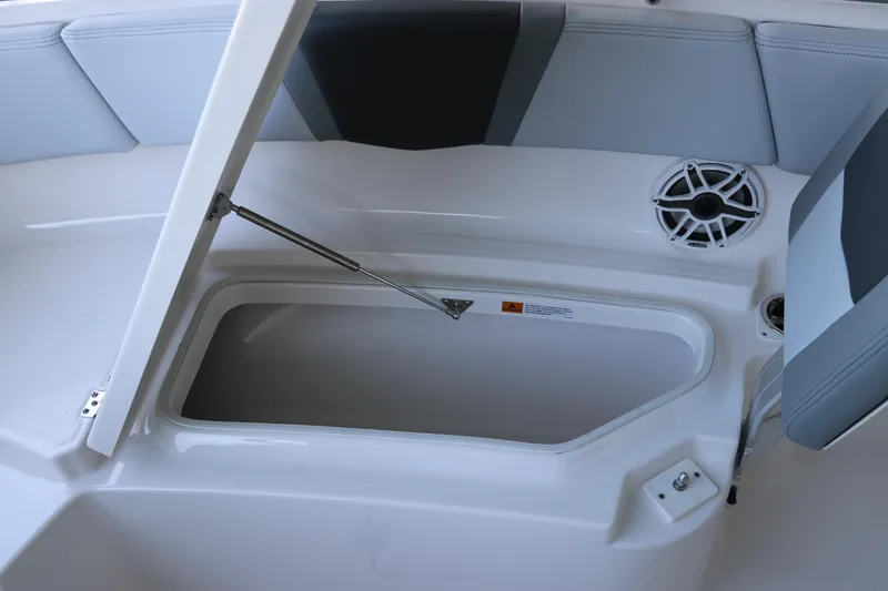 Slide: The Image of 2026 Robalo R250 Center Console boat storage compartment with open lid and speaker. - 54