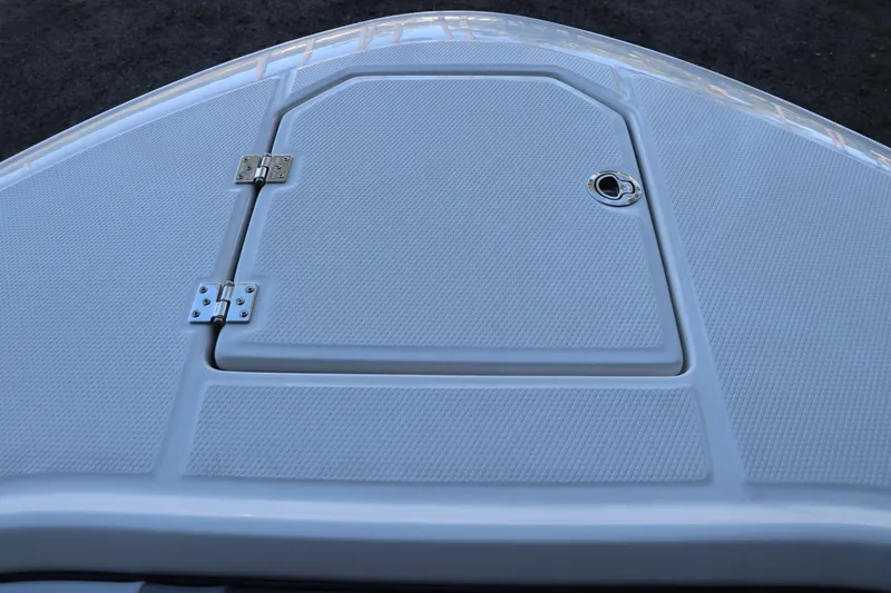 Slide: The Image of 2026 Robalo R250 Center Console boat hatch with textured surface and metal hinges. - 59