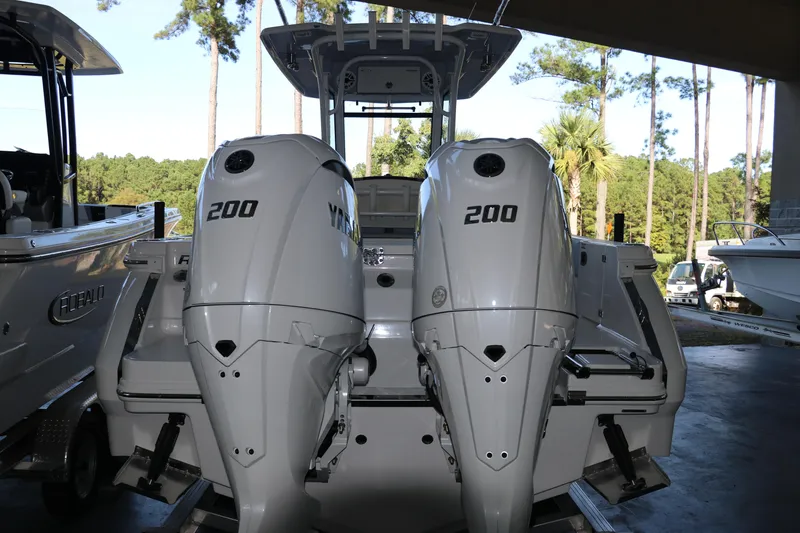Slide: The Image of 2026 Robalo R250 Center Console with twin 200 horsepower engines in a marina setting. - 6