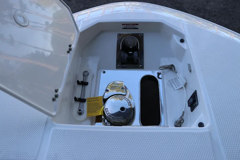 Slide: The Image of 2026 Robalo R250 Center Console anchor compartment with open hatch and tools. - 60
