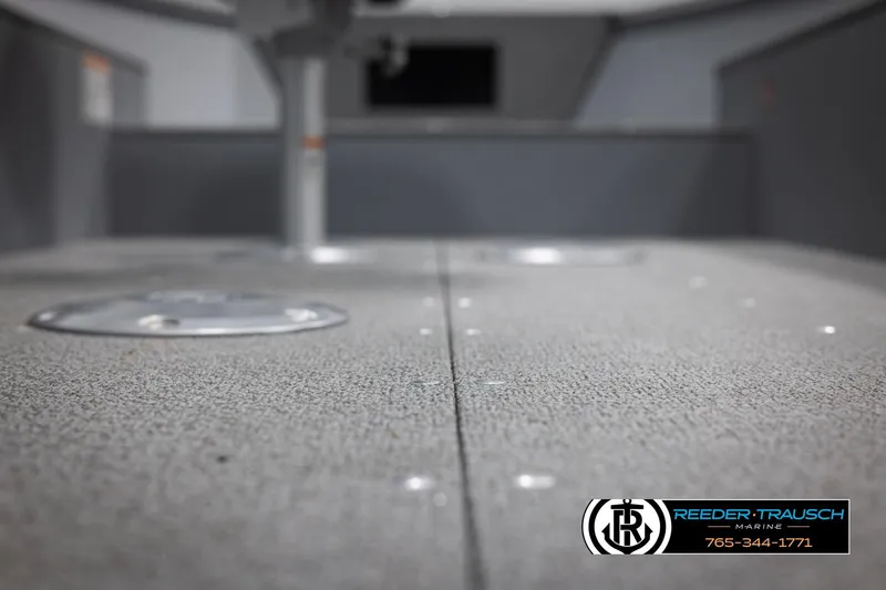 Slide: The Image of 2026 Lund 1600 Fury Tiller boat interior with carpeted flooring, Reeder-Trausch Marine logo visible. - 22