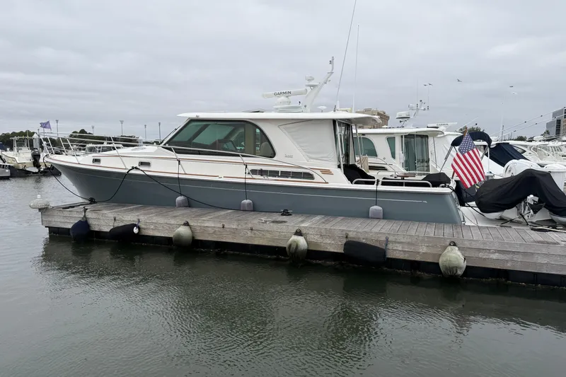Slide: The Image of 2023 Sabre 43 Salon Express yacht docked at marina with American flag. - 1