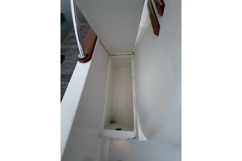 Slide: The Image of 2023 Sabre 43 Salon Express deck detail with railing and storage compartment. - 104