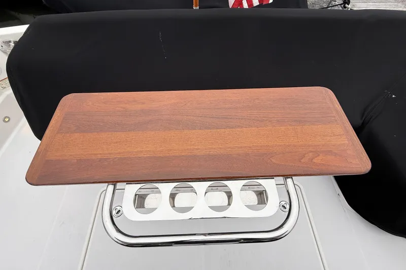 Slide: The Image of Wooden table on 2023 Sabre 43 Salon Express yacht, featuring stainless steel cup holders. - 105
