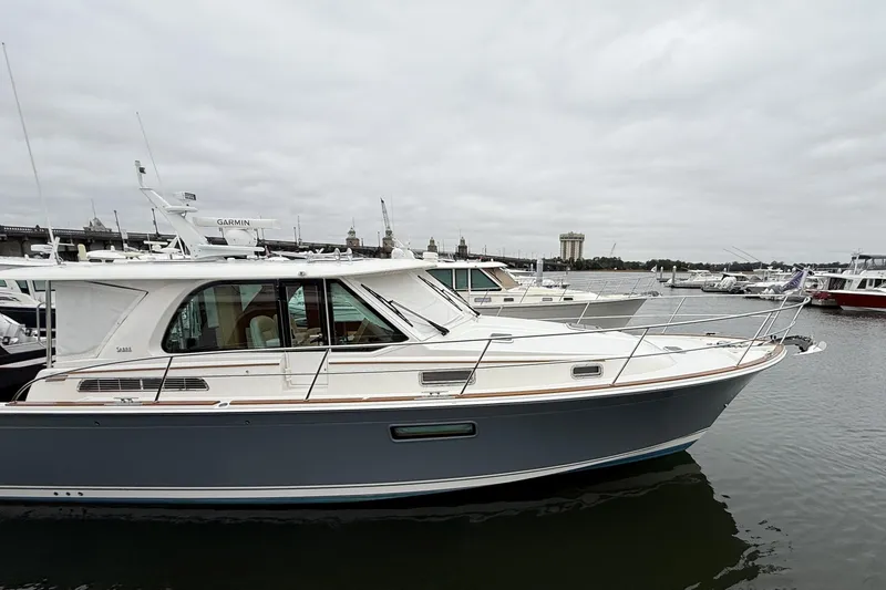 Slide: The Image of 2023 Sabre 43 Salon Express yacht docked in a marina under cloudy skies. - 111