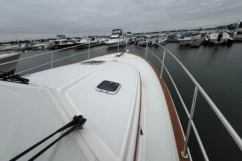 Slide: The Image of 2023 Sabre 43 Salon Express yacht docked at marina, overcast sky. - 14