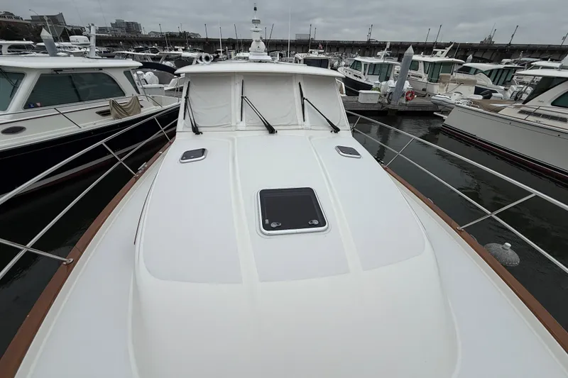 Slide: The Image of 2023 Sabre 43 Salon Express yacht docked in a marina, surrounded by other boats. - 19
