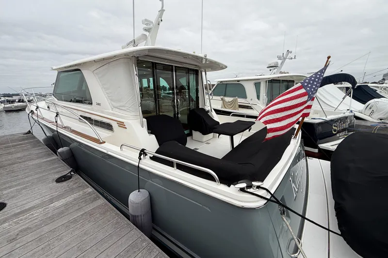Slide: The Image of 2023 Sabre 43 Salon Express yacht docked, featuring sleek design and American flag. - 2
