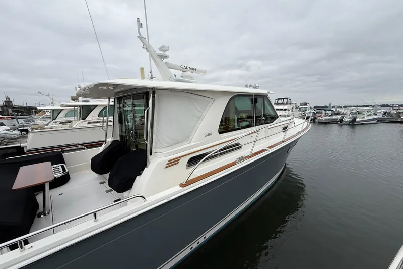 Slide: The Image of 2023 Sabre 43 Salon Express yacht docked at marina under cloudy sky. - 4