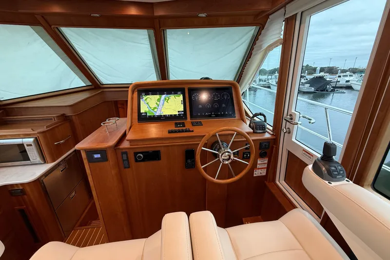 Slide: The Image of 2023 Sabre 43 Salon Express helm with navigation screens and wooden steering wheel. - 44