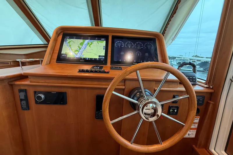 Slide: The Image of 2023 Sabre 43 Salon Express helm with navigation screens and wooden steering wheel. - 46