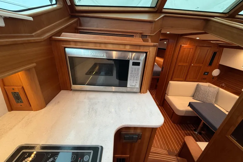 Slide: The Image of 2023 Sabre 43 Salon Express interior with microwave, seating, and wood finish. - 50