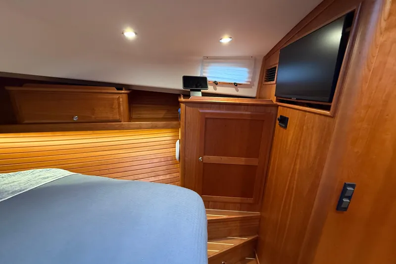 Slide: The Image of 2023 Sabre 43 Salon Express cabin interior with wood paneling and TV. - 73