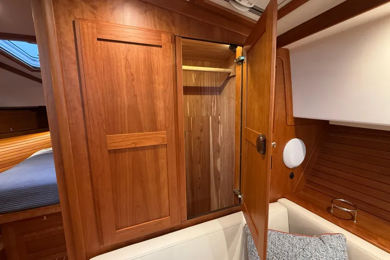 Slide: The Image of 2023 Sabre 43 Salon Express interior with wooden closet and seating area. - 87