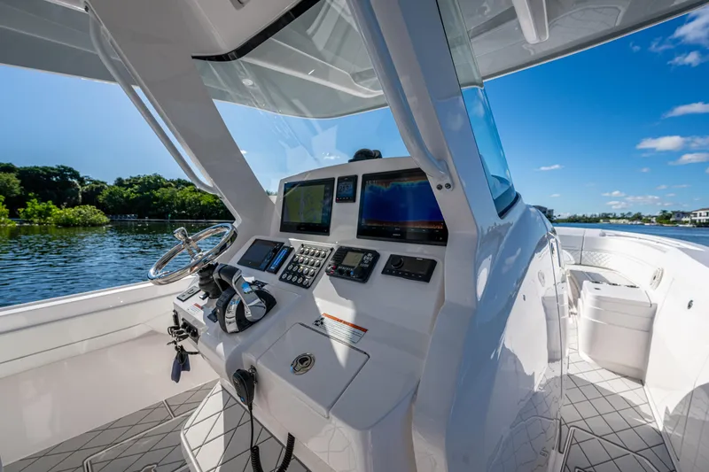 Slide: The Image of 2020 Intrepid 375 Nomad SE boat cockpit with advanced navigation systems, steering wheel, and scenic water view. - 10