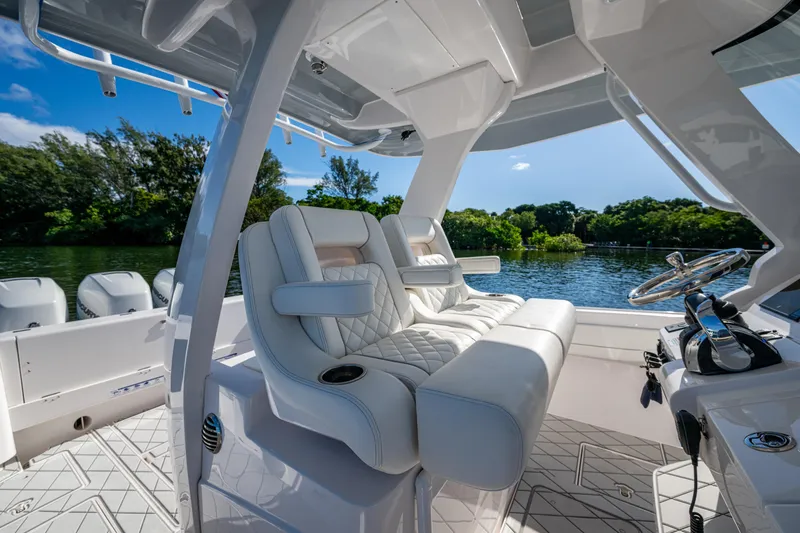 Slide: The Image of 2020 Intrepid 375 Nomad SE boat interior with luxurious seating and scenic water view. - 11