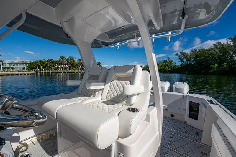 Slide: The Image of 2020 Intrepid 375 Nomad SE boat interior with luxurious seating and scenic water view. - 12