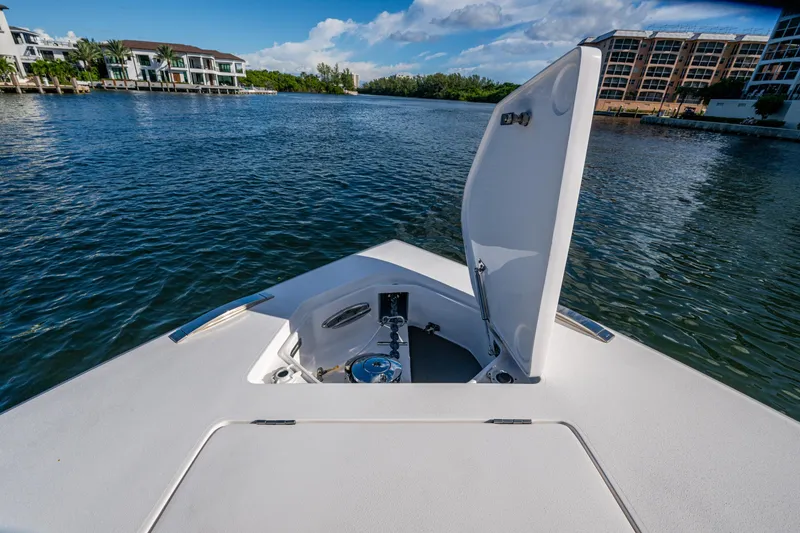 Slide: The Image of 2020 Intrepid 375 Nomad SE boat on calm water with open anchor hatch. - 16