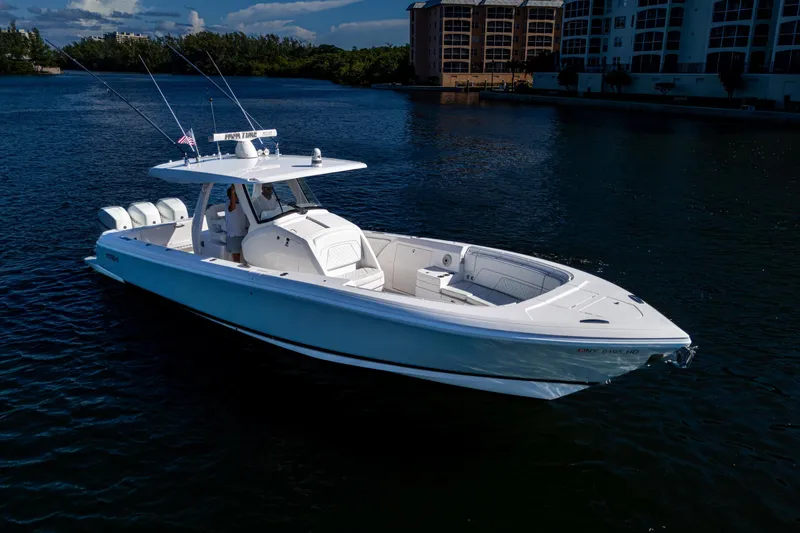 Slide: The Image of 2020 Intrepid 375 Nomad SE boat on calm water, featuring sleek design and triple engines. - 2