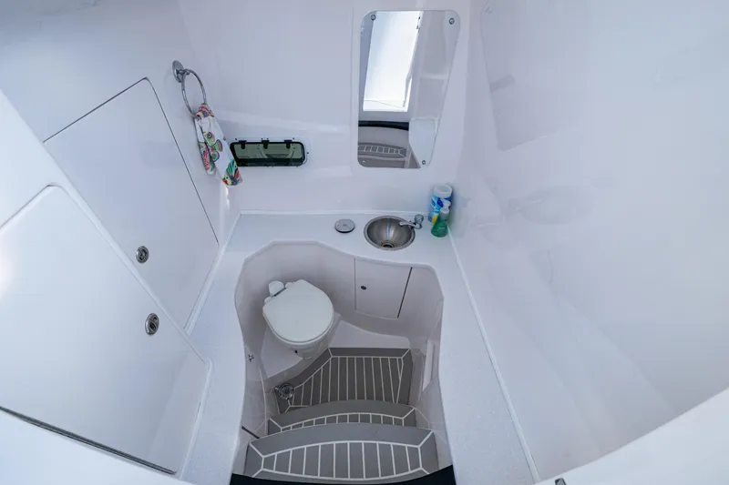 Slide: The Image of 2020 Intrepid 375 Nomad SE boat bathroom with toilet, sink, and mirror. - 24