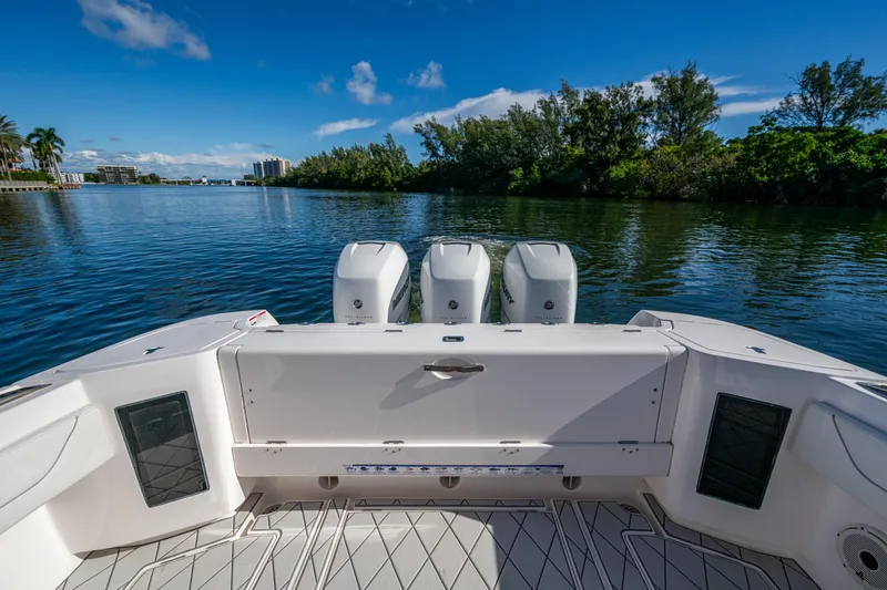 Slide: The Image of 2020 Intrepid 375 Nomad SE boat with triple engines on a calm waterway. - 30
