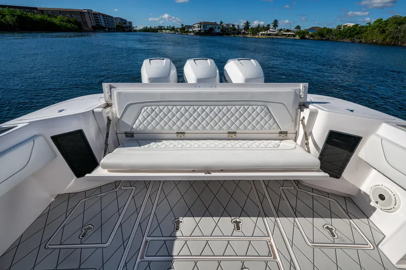 Slide: The Image of 2020 Intrepid 375 Nomad SE boat with luxurious seating and triple engines on a calm waterway. - 31