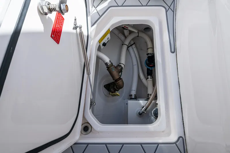 Slide: The Image of 2020 Intrepid 375 Nomad SE boat compartment with visible plumbing and fittings. - 33