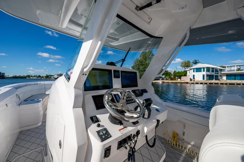 Slide: The Image of Cockpit view of 2020 Intrepid 375 Nomad SE boat with modern controls and waterfront scenery. - 8