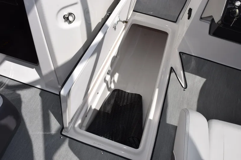 Slide: The Image of 2026 Yamaha Boats AR250 storage compartment with open hatch and interior view. - 15