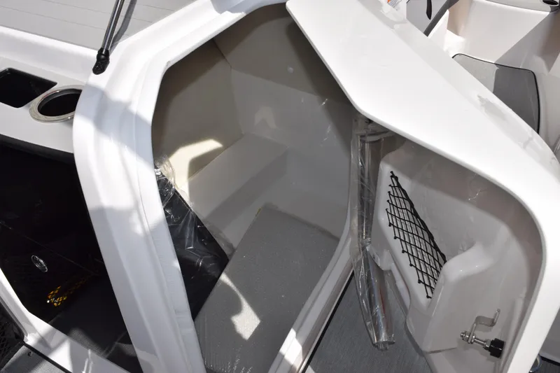 Slide: The Image of 2026 Yamaha Boats AR250 interior storage compartment with seating and netted storage. - 16