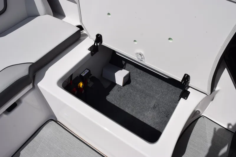 Slide: The Image of 2026 Yamaha Boats AR250 storage compartment with open lid, showcasing interior space and components. - 18