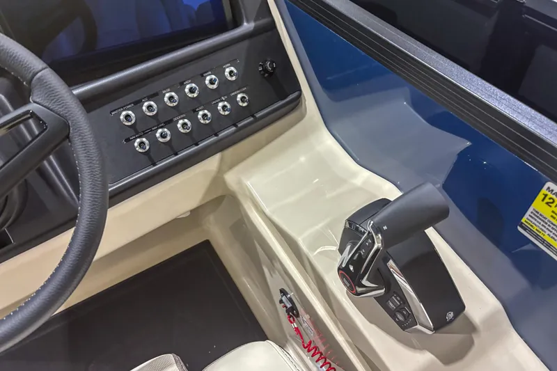 Slide: The Image of Control panel and steering of 2026 Alera M23Q boat, featuring multiple switches and throttle. - 10