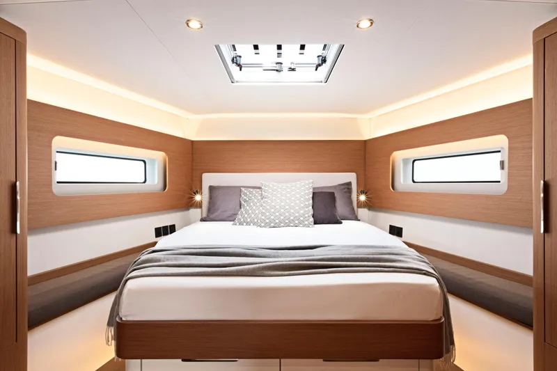 Slide: The Image of Luxurious cabin interior of 2026 Beneteau First 53 yacht, featuring modern design and cozy bedding. - 12