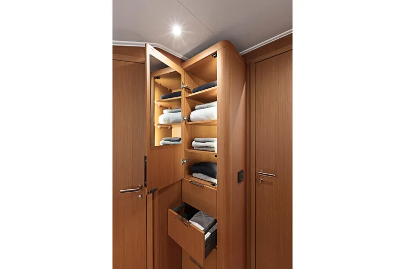 Slide: The Image of Luxurious wooden cabinet interior on 2026 Beneteau First 53 yacht, featuring neatly arranged towels. - 5