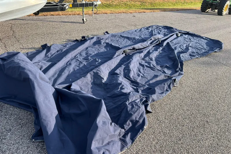 Slide: The Image of Blue boat cover on pavement, likely for 2015 Sylvan Mirage Fish 8522 Party Fish LE. - 54