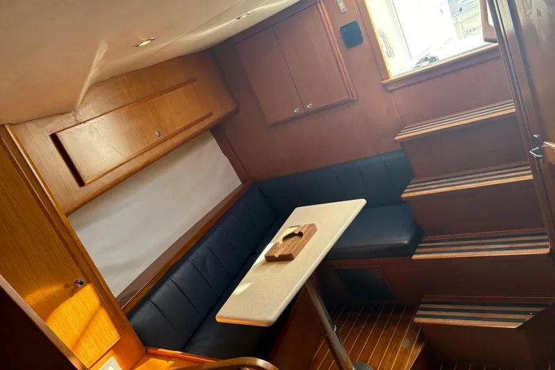 Slide: The Image of 2006 Topaz Express Cruiser interior with wooden cabinetry, seating, and stairs. - 11