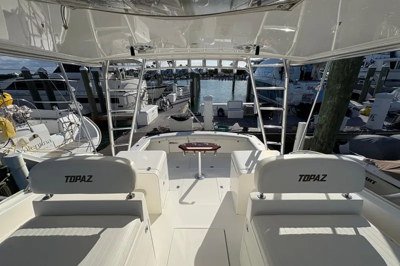 Slide: The Image of 2006 Topaz Express Cruiser at marina, showcasing spacious deck and seating. - 12