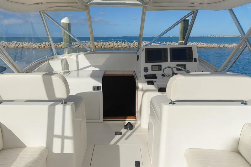 Slide: The Image of 2006 Topaz Express Cruiser helm with dual screens, white seating, and ocean view. - 8