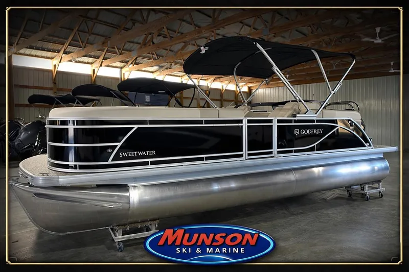 The Image of 2026 Godfrey SW 2286 SBC pontoon boat in showroom, featuring sleek design and black canopy. - 0