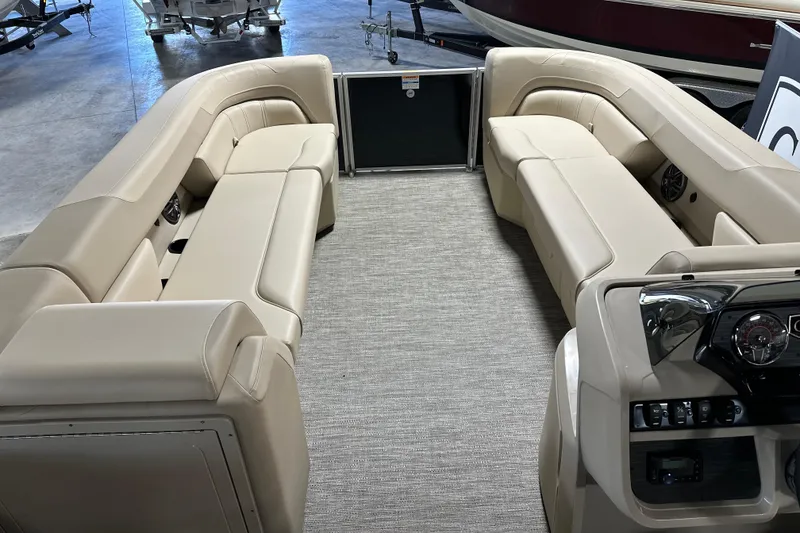 Slide: The Image of 2026 Godfrey SWEETWATER 2286 SB boat interior with beige seating and modern dashboard. - 10