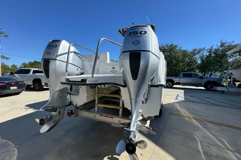 Slide: The Image of 2005 Glacier Bay 260 Canyon Runner with dual Honda 150 VTEC engines, parked outdoors. - 13