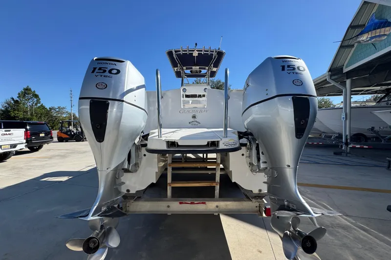 Slide: The Image of 2005 Glacier Bay 260 Canyon Runner with dual Honda 150 VTEC engines, parked outdoors. - 14