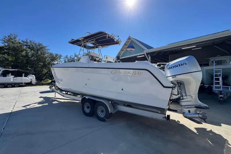 Slide: The Image of 2005 Glacier Bay 260 Canyon Runner boat on trailer, sunny day, Honda outboard motor. - 17