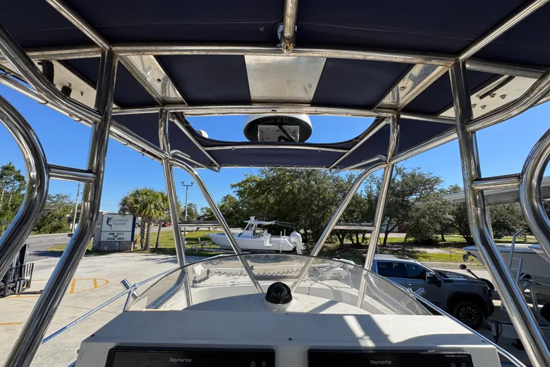 Slide: The Image of 2005 Glacier Bay 260 Canyon Runner boat with canopy and control panel, docked outdoors. - 29