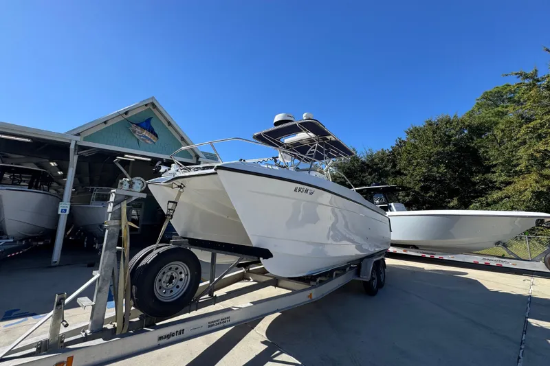 Slide: The Image of 2005 Glacier Bay 260 Canyon Runner boat on trailer, parked outdoors under clear blue sky. - 4