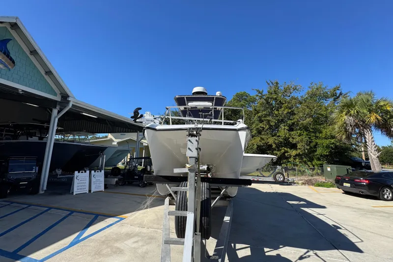 Slide: The Image of 2005 Glacier Bay 260 Canyon Runner boat on trailer, parked outdoors under clear blue sky. - 6