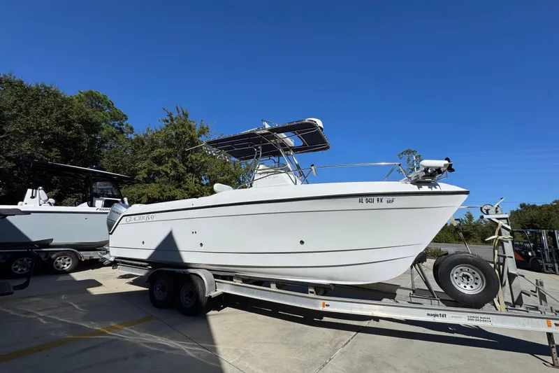 Slide: The Image of 2005 Glacier Bay 260 Canyon Runner boat on trailer, parked outdoors under clear blue sky. - 9