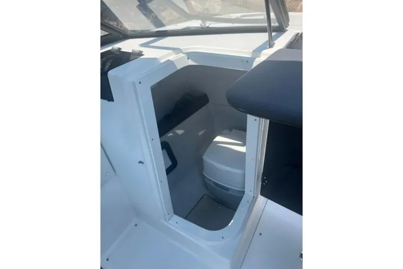 Slide: The Image of 2019 Rinker Q3 OB boat interior with compact cabin space and seating. - 11