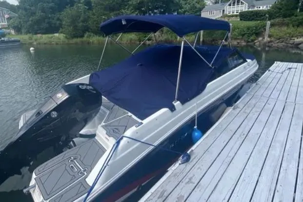 Slide: The Image of 2019 Rinker Q3 OB boat docked with blue canopy and cover. - 5