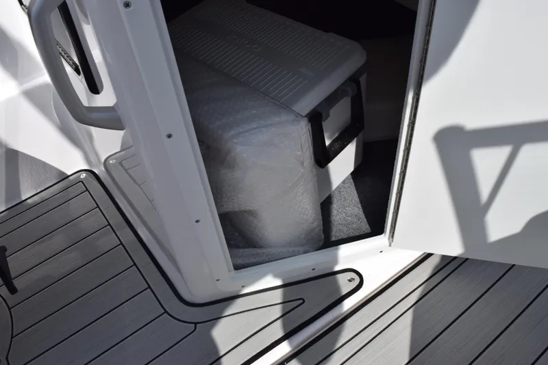 Slide: The Image of 2026 Yamaha Boats 195S storage compartment with cooler and bubble wrap. - 18